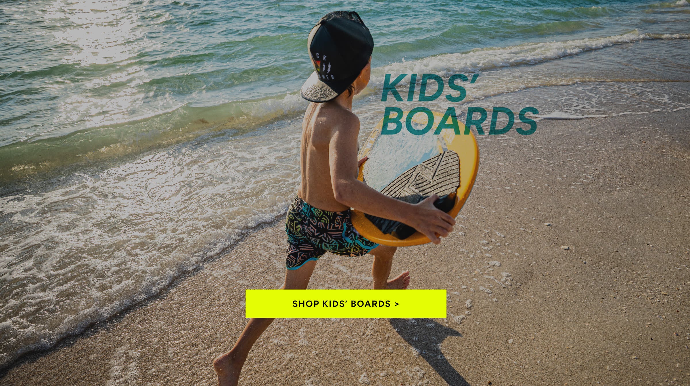 Young skimboarder carrying a Wave Zone board at the beach